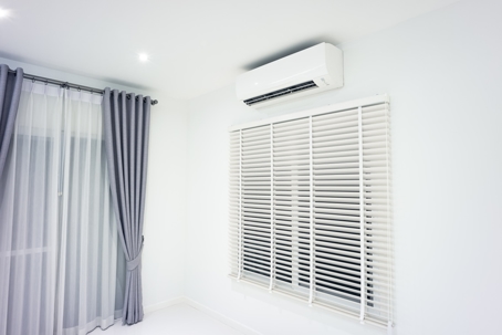 Blinds and air conditioner in room of home or house building.